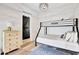 Stylish bedroom features a bunk bed, a blue rug, a dark barn door, and a wooden dresser at 11189 Serenbe Ln, Chattahoochee Hills, GA 30268