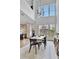 Dining room area showcasing view of kitchen, hardwood floors, bright light from multiple windows and statement pendant light at 11189 Serenbe Ln, Chattahoochee Hills, GA 30268