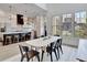 Open concept kitchen/dining with hardwood floors, bright light from multiple windows and statement pendant light at 11189 Serenbe Ln, Chattahoochee Hills, GA 30268
