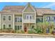 Charming two-story townhome with a cozy balcony, red front door and beautiful landscaping at 11189 Serenbe Ln, Chattahoochee Hills, GA 30268