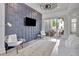 Living room showcasing paneled accent wall, sliding doors to outdoor patio, and ceiling fan at 11189 Serenbe Ln, Chattahoochee Hills, GA 30268