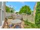 Back patio features stone flooring, a table with chairs, wooden fence, and greenery for outdoor entertaining at 11189 Serenbe Ln, Chattahoochee Hills, GA 30268