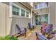 Private patio features stone pavers, Adirondack chairs, lush landscaping, and a sliding glass door entrance at 11189 Serenbe Ln, Chattahoochee Hills, GA 30268