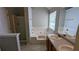 Bathroom features a shower and tub combo with white tile surround and double sink vanity at 1780 Spring Hill Cv, Lithonia, GA 30058