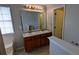 Bright bathroom featuring a double sink vanity with wood cabinets and a large mirror at 1780 Spring Hill Cv, Lithonia, GA 30058