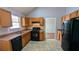 Well-lit kitchen featuring wooden cabinets, tile flooring, and modern appliances, offering a functional cooking space at 1780 Spring Hill Cv, Lithonia, GA 30058