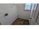 Functional laundry room with washer/dryer hookups, tile floor, and a storage shelf, offering convenience at 1780 Spring Hill Cv, Lithonia, GA 30058
