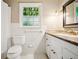 Bathroom with toilet, vanity, and shower with white tile at 3932 Granger Dr, Brookhaven, GA 30341