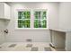 Room features gray walls, tile floor, two windows, cabinets, and table at 3932 Granger Dr, Brookhaven, GA 30341