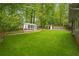 Backyard shed surrounded by green lawn and lush landscaping providing storage and privacy at 3932 Granger Dr, Brookhaven, GA 30341