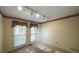A sunny bedroom features two windows, neutral walls, and track lighting at 4703 Waverly Walk, Douglasville, GA 30135