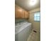 Bright laundry room featuring a window and cabinets above the washer and dryer at 4703 Waverly Walk, Douglasville, GA 30135