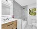 A bright bathroom featuring a modern shower, vanity with square mirror, and tiled floors at 5840 Crabapple Sw Dr, Mableton, GA 30126