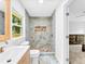 A bright bathroom with marble tiling, a glass door shower and pebble tile flooring at 5840 Crabapple Sw Dr, Mableton, GA 30126