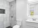 A bright bathroom featuring a modern shower, vanity with square mirror, and dark tiled floors at 5840 Crabapple Sw Dr, Mableton, GA 30126