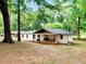 Quaint single-story house with a inviting covered porch, set amidst a beautiful green and wooded landscape at 5840 Crabapple Sw Dr, Mableton, GA 30126