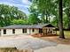 One-story home boasts an inviting covered porch with a swing, set within a lush, tree-filled landscape at 5840 Crabapple Sw Dr, Mableton, GA 30126