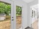 Hallway with white doors leading to a wooden deck with an amazing view of lush greenery at 5840 Crabapple Sw Dr, Mableton, GA 30126