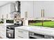 Well-lit kitchen featuring stainless steel appliances, white cabinets, and marble backsplash at 5840 Crabapple Sw Dr, Mableton, GA 30126