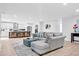 Bright, open-concept living area with a gray sectional, kitchen view, and modern design at 5840 Crabapple Sw Dr, Mableton, GA 30126