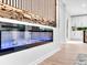 Modern living room with a sleek electric fireplace, stone wall, and view into the kitchen at 5840 Crabapple Sw Dr, Mableton, GA 30126