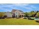 The backyard features a pool, outdoor seating, manicured lawn and mature trees at 210 Tifton Ln, Roswell, GA 30075