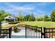 Landscaped backyard featuring a pool, pool house, lush lawn and mature trees on a sunny day at 210 Tifton Ln, Roswell, GA 30075