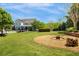 Expansive backyard with lush lawn, mature trees, fire pit, and a view of the elegant home at 210 Tifton Ln, Roswell, GA 30075