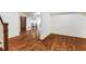 Open basement area with hardwood floors, brick wall, and view to the gathering room at 210 Tifton Ln, Roswell, GA 30075