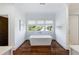 Bright bathroom with standalone tub, hardwood floors, and large windows that offer natural light and views at 210 Tifton Ln, Roswell, GA 30075