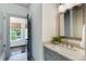 Bathroom vanity with granite countertop, modern sink, and mirror next to a door leading to the bedroom at 210 Tifton Ln, Roswell, GA 30075