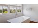 Bathroom featuring a freestanding tub with chrome faucet and view of surrounding trees and blue skies at 210 Tifton Ln, Roswell, GA 30075