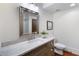 This modern bathroom features a granite countertop, framed mirror, modern lighting, and a toilet at 210 Tifton Ln, Roswell, GA 30075