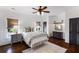 Bedroom featuring wood plank walls, ceiling fan, windows, door to a connecting space, and area rug at 210 Tifton Ln, Roswell, GA 30075