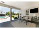 Cozy covered porch featuring a comfortable seating area, TV and view of the pool at 210 Tifton Ln, Roswell, GA 30075