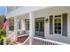 Inviting front porch featuring brick flooring, porch swing, and classic architectural details at 210 Tifton Ln, Roswell, GA 30075