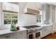 Bright kitchen featuring professional stainless steel appliances and large windows overlooking greenery at 210 Tifton Ln, Roswell, GA 30075