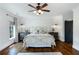 Cozy main bedroom with hardwood floors, a fan, and a sliding barn door to ensuite at 210 Tifton Ln, Roswell, GA 30075