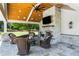Inviting outdoor living space featuring a stone fireplace, ceiling fan, and comfortable seating area at 210 Tifton Ln, Roswell, GA 30075
