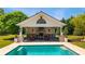 Stunning pool house with stone fireplace, outdoor seating, and a clear view of the refreshing pool at 210 Tifton Ln, Roswell, GA 30075