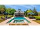 Inviting pool area featuring a spa, surrounding patio, pool house, and outdoor seating at 210 Tifton Ln, Roswell, GA 30075