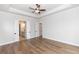 Spacious bedroom with tray ceilings, ceiling fan, and gleaming hardwood floors at 2381 Siskin Square Rd, Duluth, GA 30096
