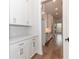 Butler's pantry with white cabinets, marble countertops, and wood floors at 2381 Siskin Square Rd, Duluth, GA 30096