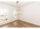 Bright dining area showcasing large windows, hardwood floors, a stylish chandelier, and neutral walls at 2381 Siskin Square Rd, Duluth, GA 30096