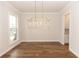 Dining room featuring hardwood floors, elegant lighting fixture, and view of the butler's pantry at 2381 Siskin Square Rd, Duluth, GA 30096