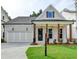 Charming home featuring a two-car garage, a welcoming front porch with wooden beams, and a well-manicured lawn at 2381 Siskin Square Rd, Duluth, GA 30096