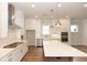 Spacious kitchen with a large island, stainless steel appliances, white cabinets, and hardwood floors at 2381 Siskin Square Rd, Duluth, GA 30096