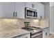 Modern kitchen featuring stainless steel appliances and sleek countertops with tile backsplash at 2710 Sandy Irwin Sw Ct, Marietta, GA 30064