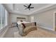 Spacious main bedroom with a decorative sofa in the sitting area, ceiling fan, and tray ceilings at 2710 Sandy Irwin Sw Ct, Marietta, GA 30064