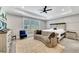 Bright main bedroom featuring tray ceilings, ceiling fan, a decorative sofa, and a cozy rug at 2710 Sandy Irwin Sw Ct, Marietta, GA 30064